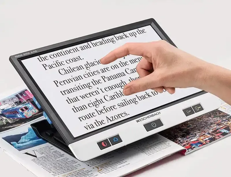 Electronic magnifier displaying enlarged text and magazine.